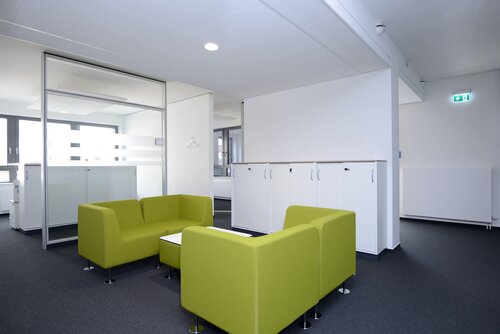 Ein moderner Wartebereich mit zwei hellgrünen Sofas und einem Couchtisch. Ein Teil der Büroräume der Pensionskasse der Hamburger Hochbahn Aktiengesellschaft -VVaG-.