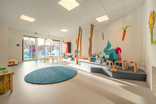 Ein moderner Gruppenraum in einer Kindertagesstätte mit einer blauen Matte und einer Spielnische mit Hasenmotiv. Die Pensionskasse der Hamburger Hochbahn Aktiengesellschaft -VVaG- unterstützt die Vereinbarkeit von Beruf und Familie.