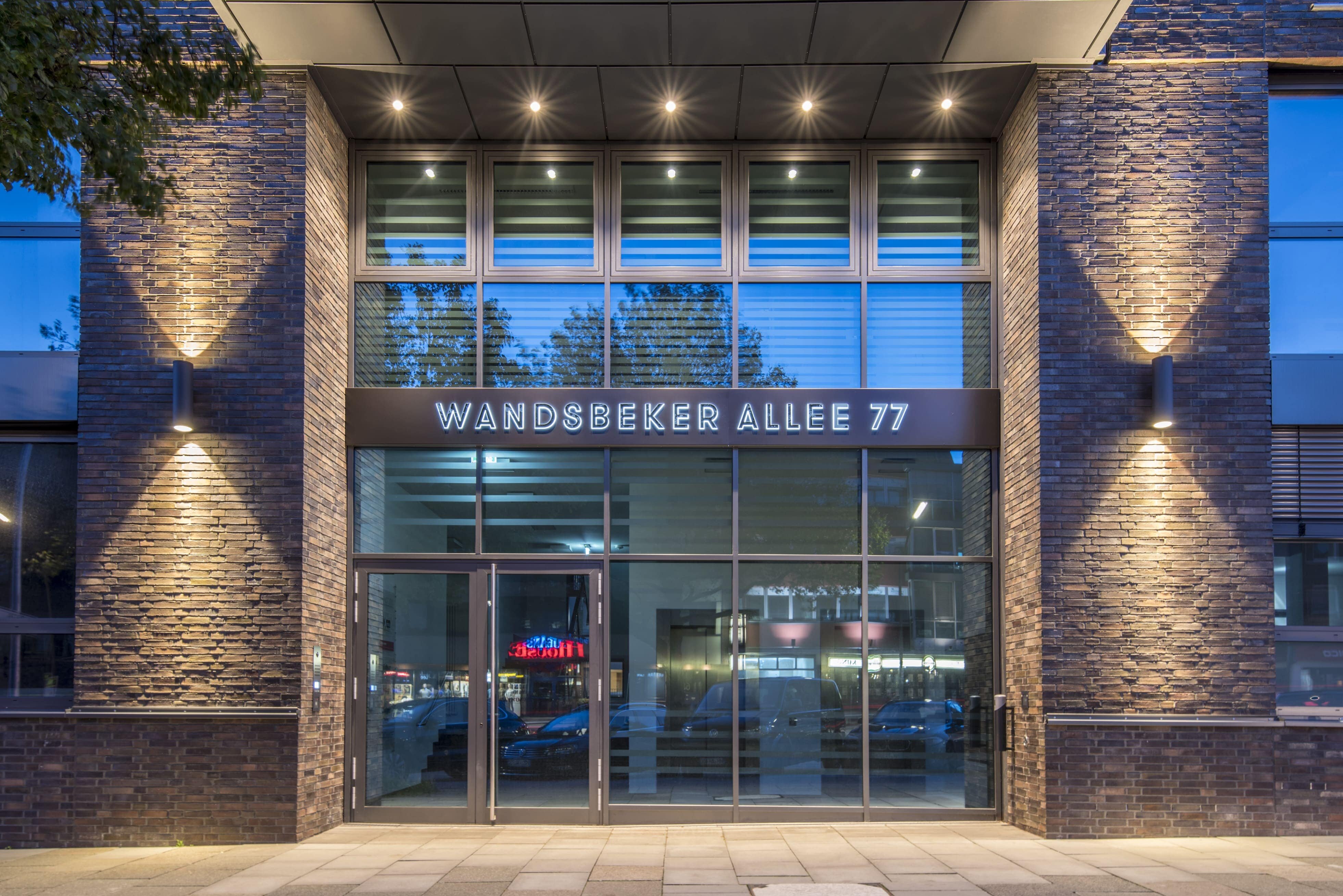 Der beleuchtete Eingang des Bürogebäudes in der Wandsbeker Allee 77, dem Sitz der Pensionskasse der Hamburger Hochbahn Aktiengesellschaft -VVaG-.