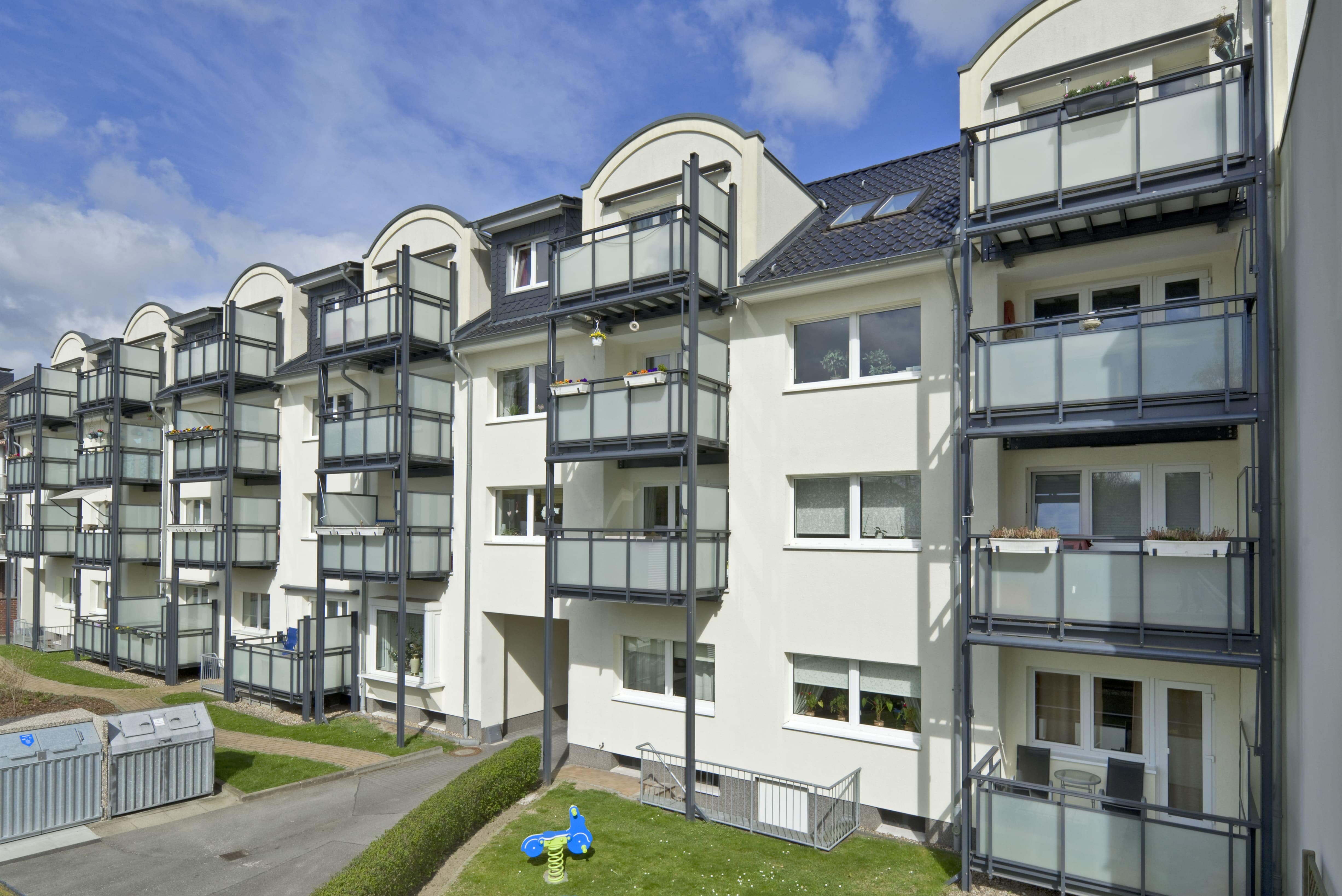Eine moderne Mehrfamilienhauszeile mit vielen Balkonen aus Glas und Metall. Ein Beispiel für die Immobilien-Kapitalanlagen der Pensionskasse der Hamburger Hochbahn Aktiengesellschaft -VVaG-.